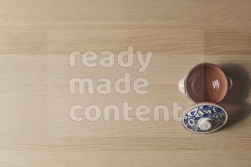 إناء فخاري متعدد الألوان على خلفية خشبية فاتحة