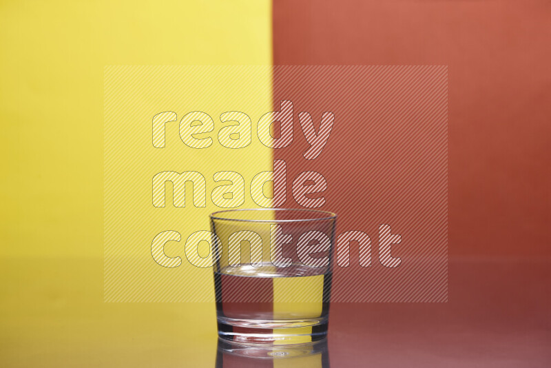 The image features a clear glassware filled with water, set against yellow and dark orange background