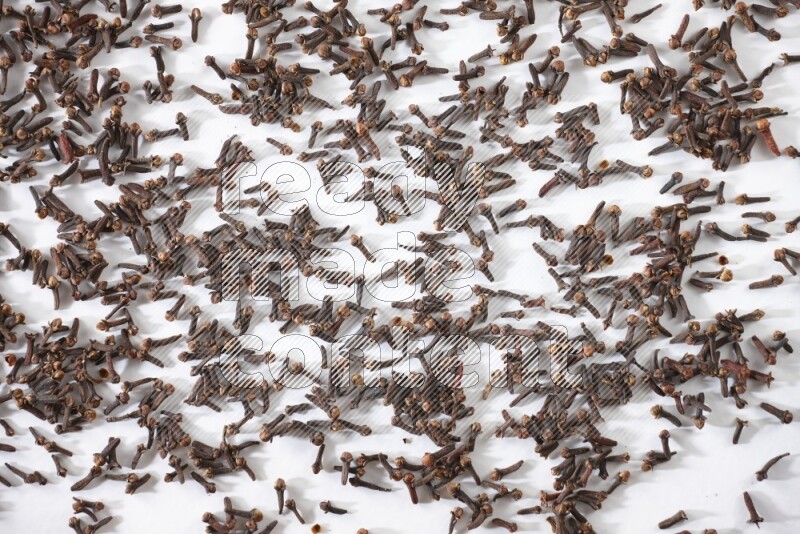 Cloves spread on white flooring