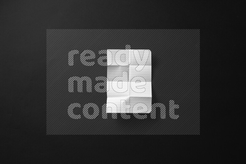 Folded notebook sheet on black background