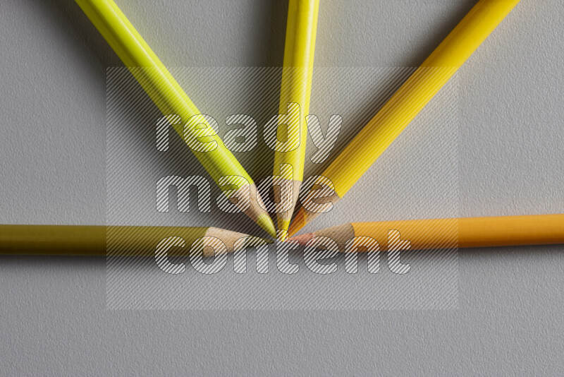 An arrangement of colored pencils in different colors on grey background