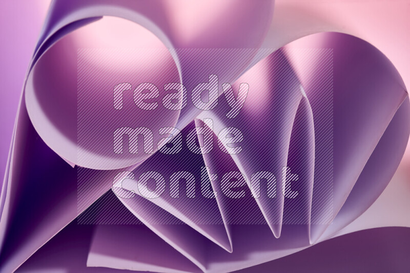 An artistic display of paper folds creating a harmonious blend of geometric shapes, highlighted by soft lighting in purple tones