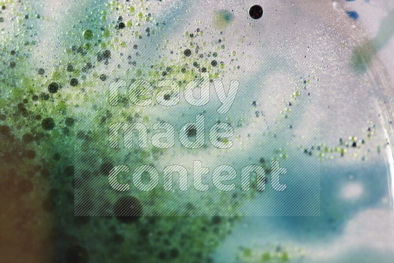 Close-ups of abstract green and blue watercolor drops on oil Surface on white background