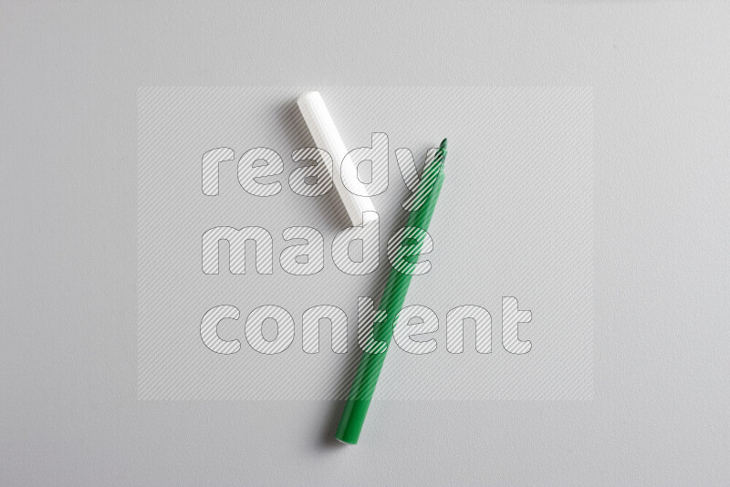 A close-up showing an open single coloring pen with a cap on grey background