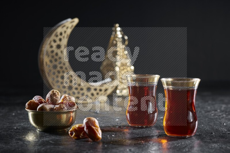 تمر مع مشروبات ساخنة وفوانيس ذهبية علي خلفية سوداء خشبية