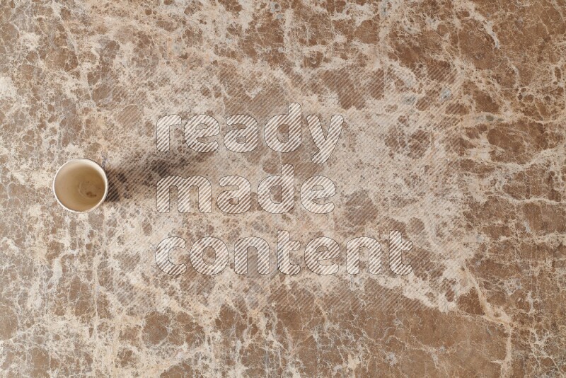 A pottery cup on beige marble background