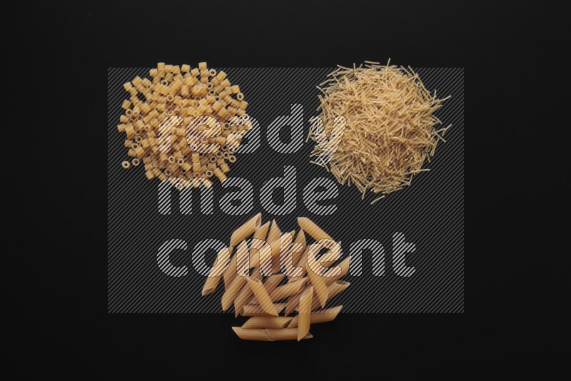 Different pasta types in bunches on black background