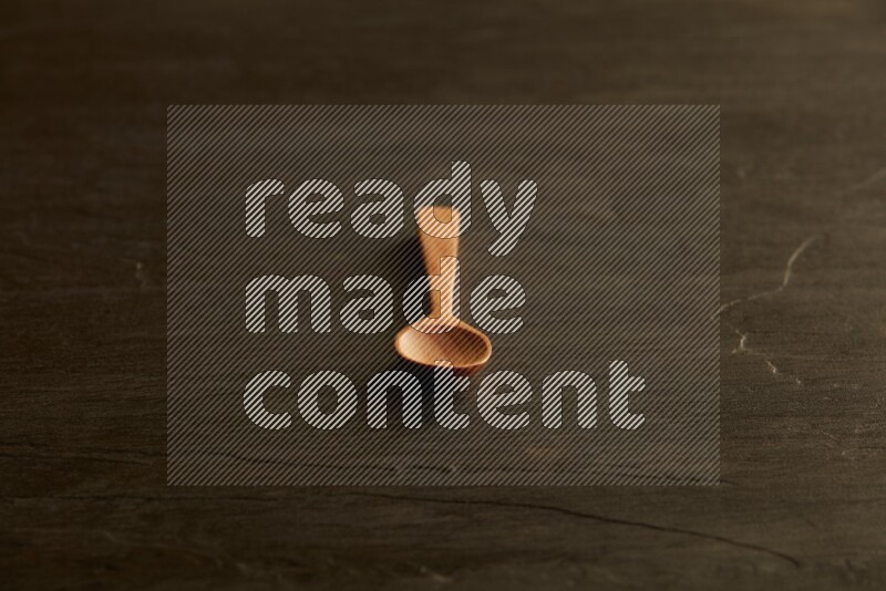 wooden spoon on black slate background