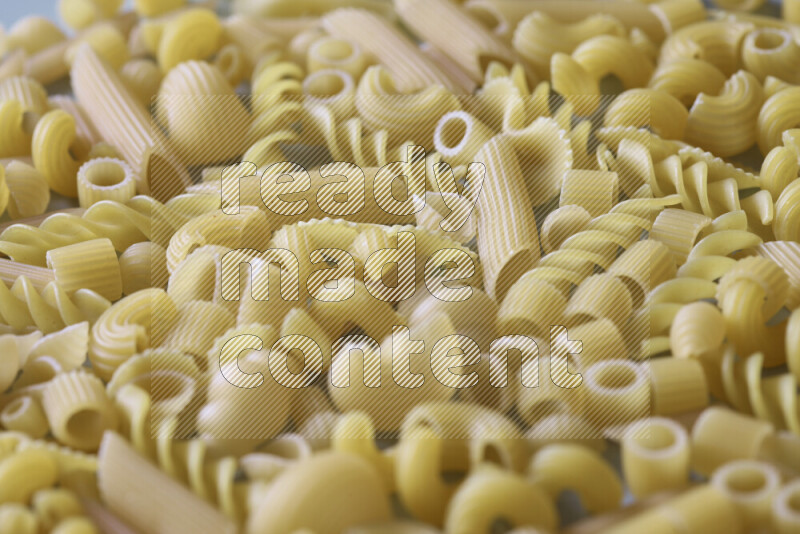 Different pasta types on light blue background