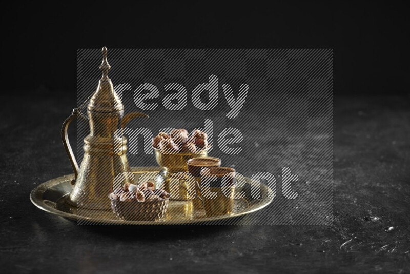 Nuts with dates and a drink on a metal tray in a dark setup