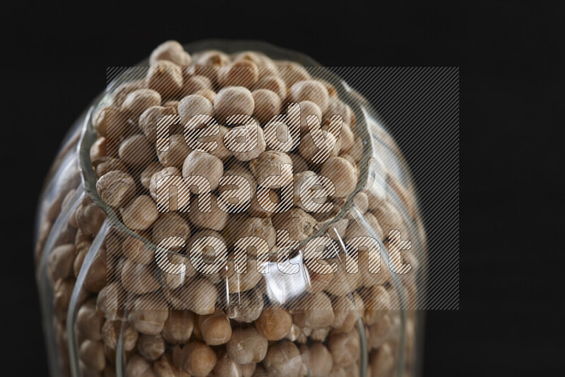 Chickpeas in a glass jar on black background