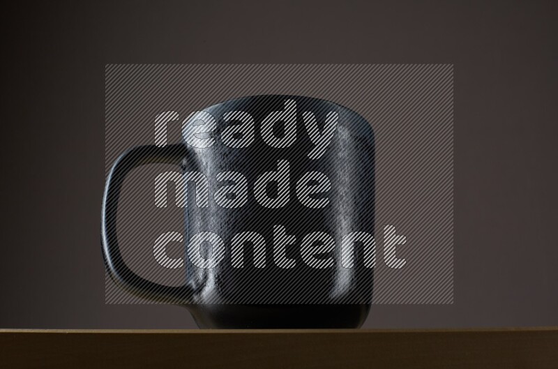 Low angle shot of a black cup on grey background