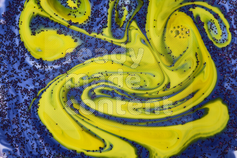 A close-up of sparkling purple glitter scattered on swirling blue and yellow background