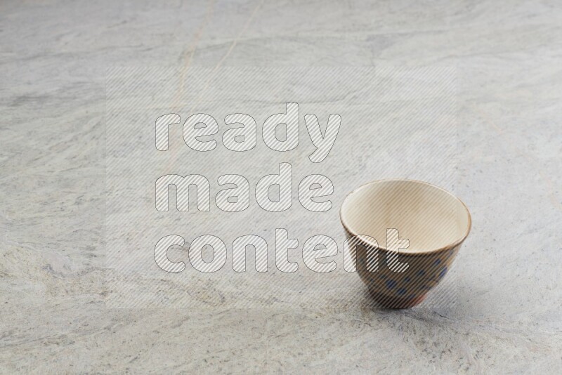A multicolored pottery bowl on grey marble background