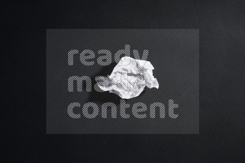 Crumpled notebook sheet on black background