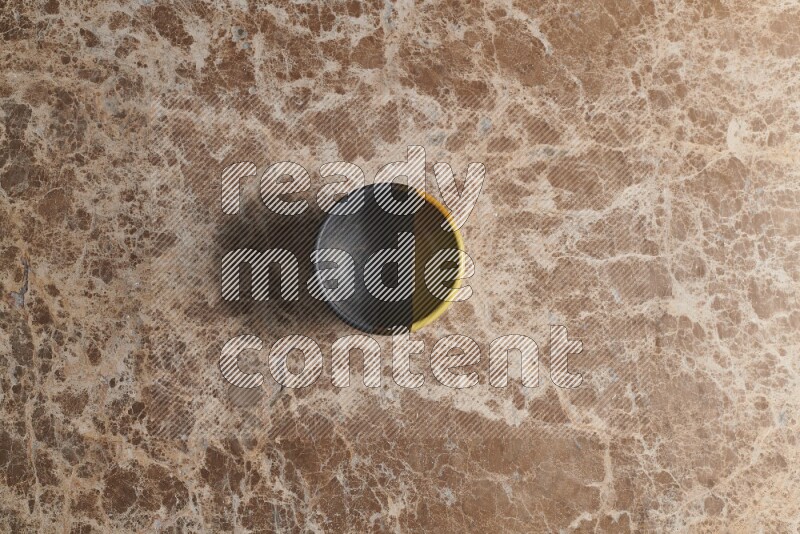 A multicolored pottery bowl on beige marble background