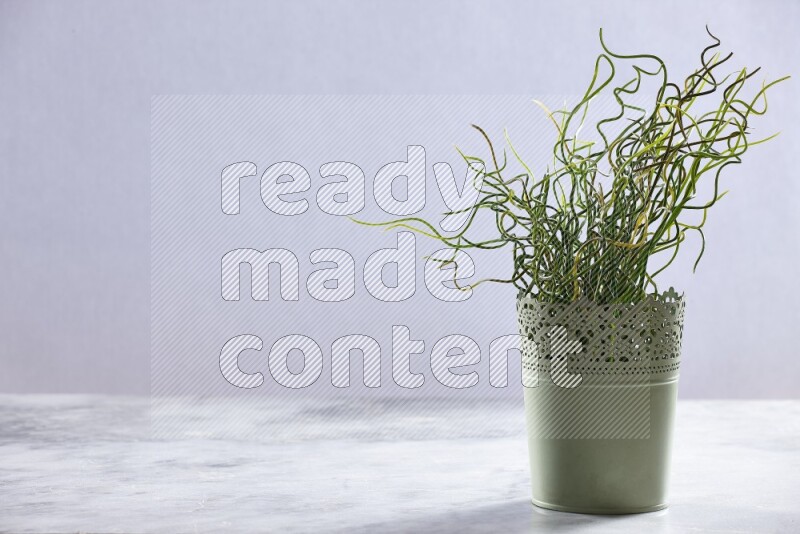 Artificial plant in green decorative pot on grey marble background