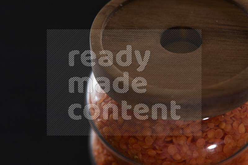 Lentils in a glass jar on black background