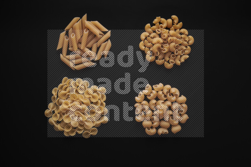 Different pasta types in bunches on black background