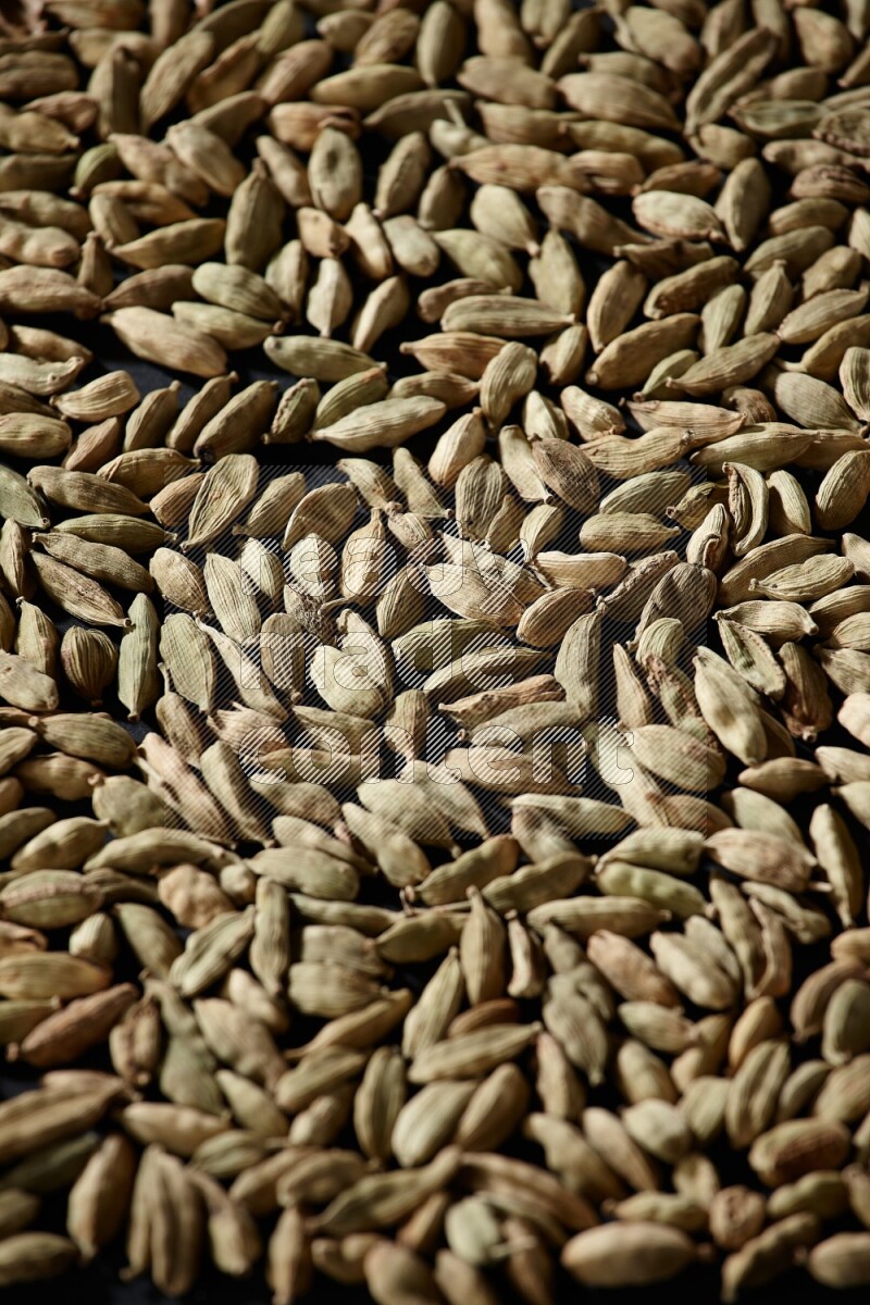 Cardamom seeds filling the frame on black flooring