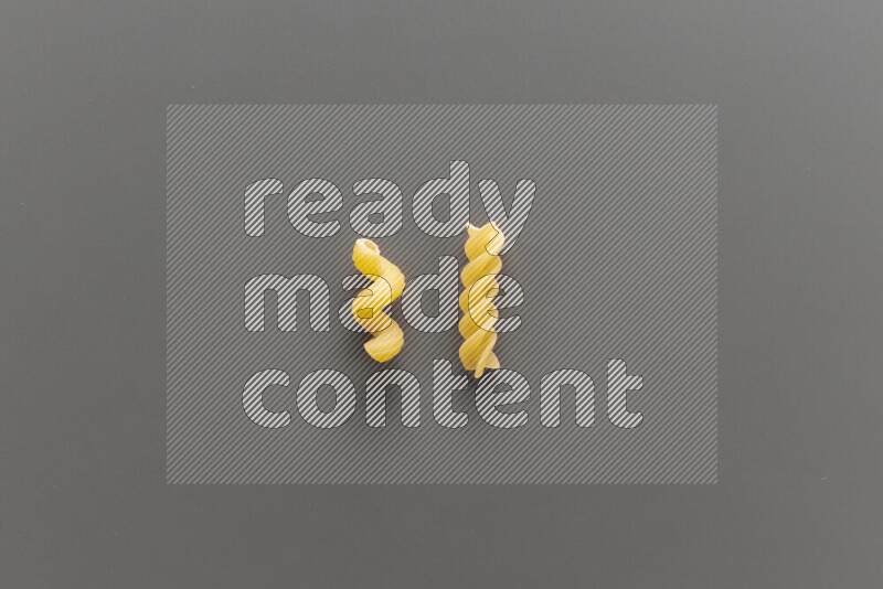 Twist pasta with other types of pasta on grey background