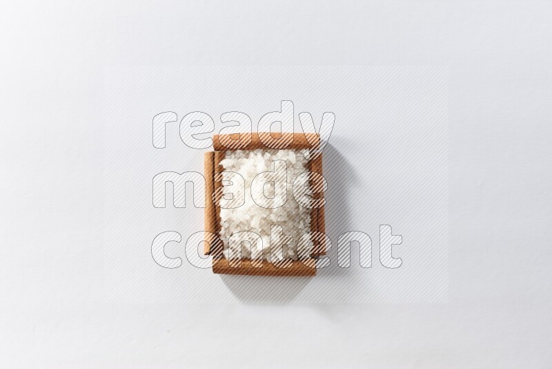 A single square of cinnamon sticks full of salt on white flooring