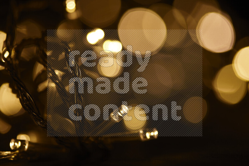 Light bulbs glowing against backdrop of golden bokeh