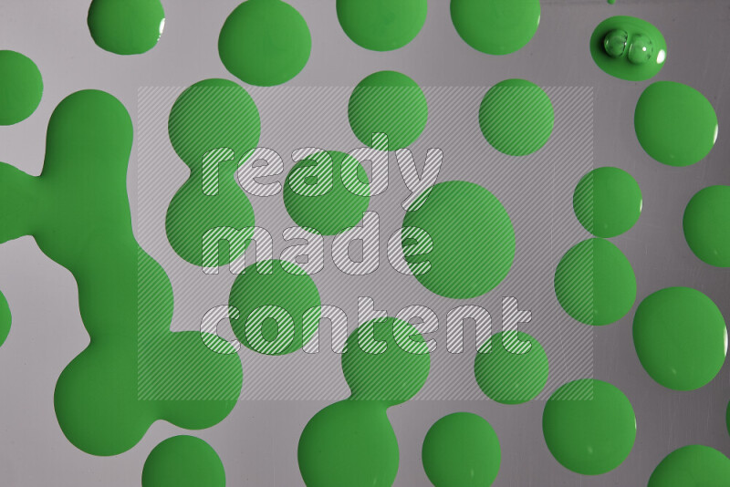 Close-ups of abstract green paint droplets on the surface