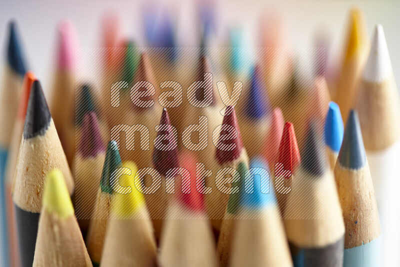 The image captures a close-up of sharpened colored pencils on multicolored background