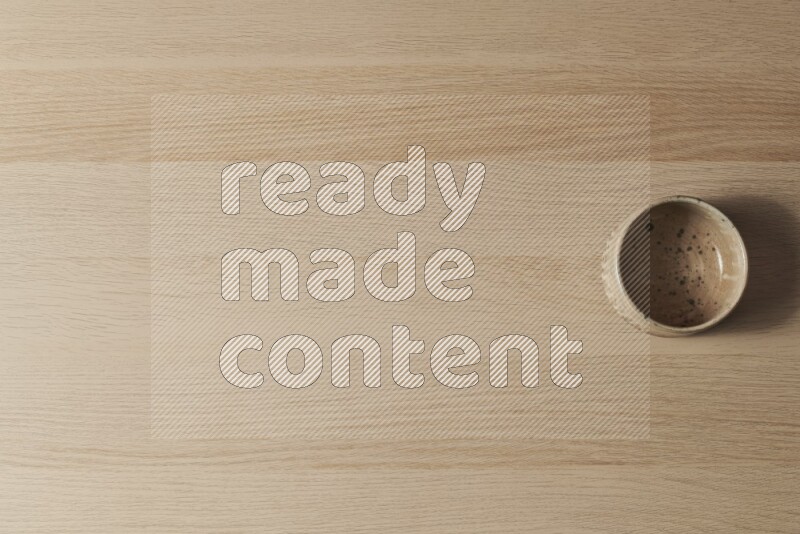 وعاء فخاري متعدد الألوان على خلفية خشبية فاتحة