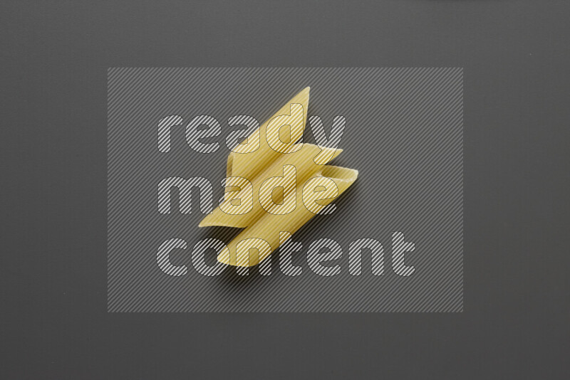Penne pasta on grey background