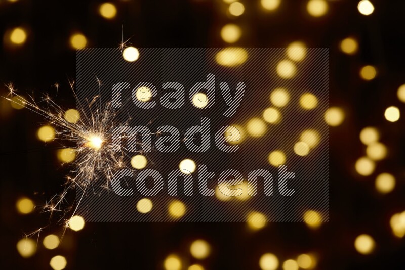 Sparkler candle with yellow light bokeh background