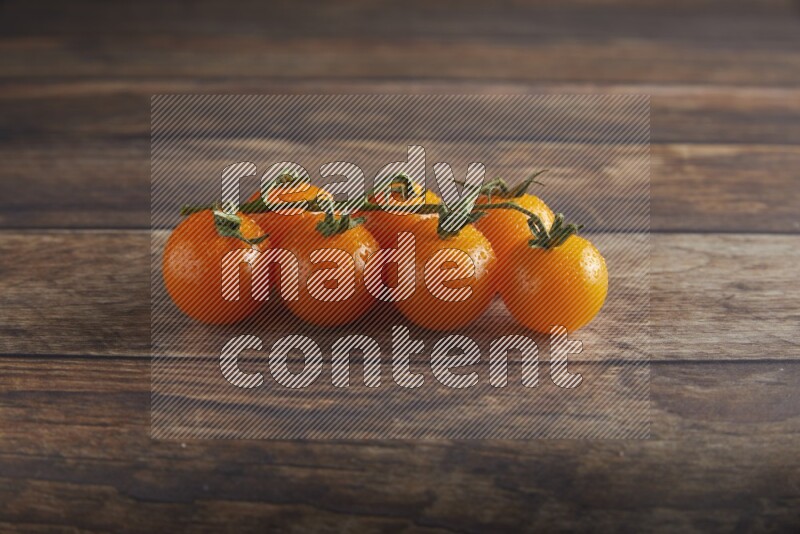 Orange cherry tomato vein on a textured wooden background 45 degree