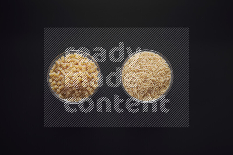Different pasta types in glass bowls on black background