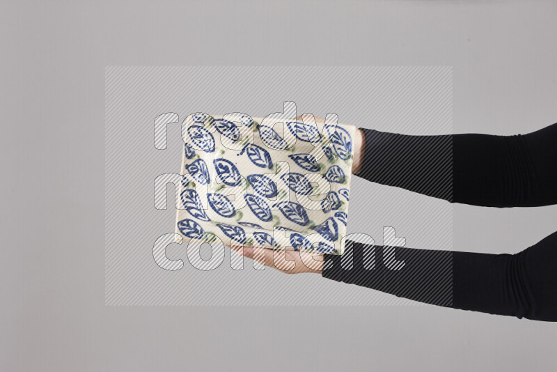 A woman in black abaya holding different pottery essentials in different positions