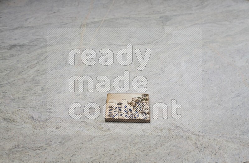 Top view shot of a pottery coaster\ tile on beige marble flooring