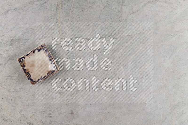 A decorative pottery plate on grey marble background