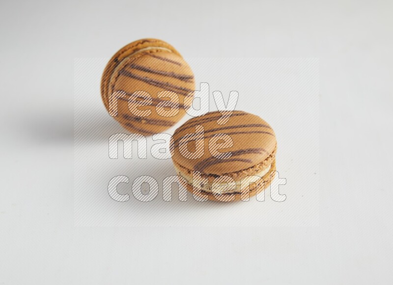 45º Shot of two light brown  Almond Cream macarons on white background