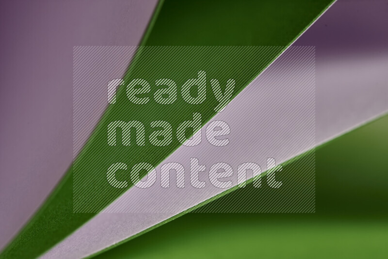 An abstract art showing purple and green paper sheets arranged in an overlapping curves