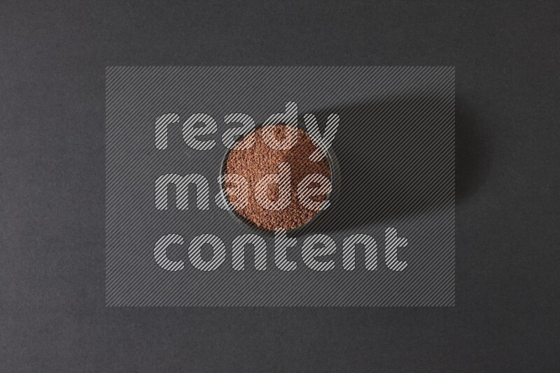 وعاء فخاري أسود ممتلئ ببذور حب الرشاد على أرضية سوداء