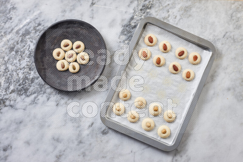 Ghoriba step by step with its ingredient, flour, powdered sugar, ghee and nuts on grey marble background