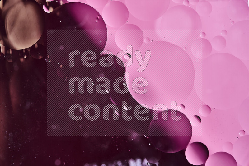 Close-ups of abstract oil bubbles on water surface in shades of purple and pink