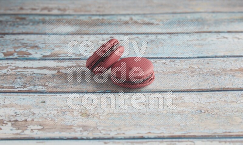45º Shot of two Red Cherry macarons on light blue wooden background