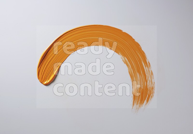An orange half circular painting brush stroke on white background
