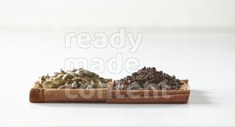 2 squares of cinnamon sticks full of cloves and cardamom on white flooring