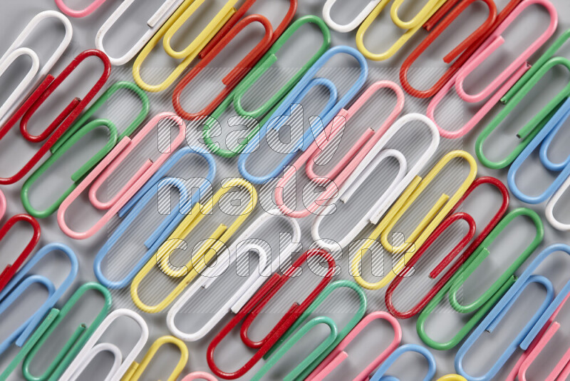 Multicolored paper clips isolated on a grey background