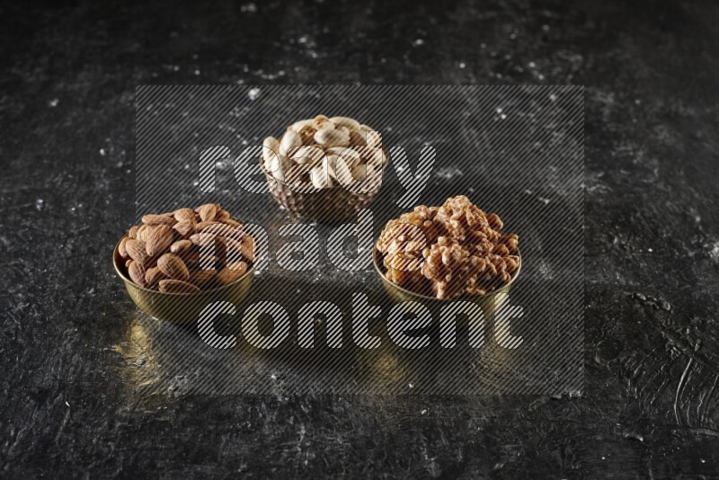 Nuts in a metal bowl in a dark setup