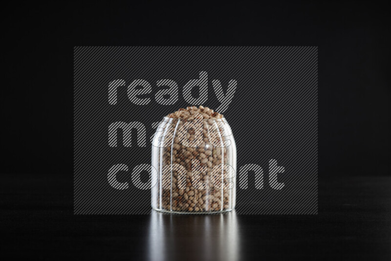 Black-eyed peas in a glass jar on black background