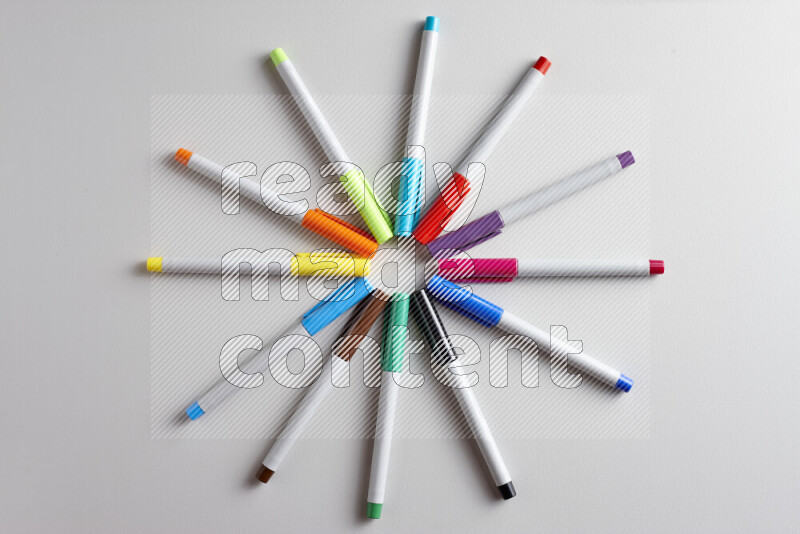 An arrangement of coloring pens in different colors on grey background