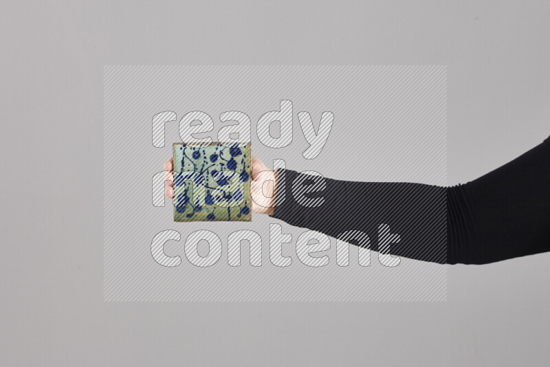 A woman in black abaya holding different pottery essentials in different positions